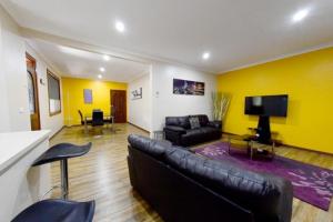 贝纳拉Benalla Apartments的客厅配有真皮沙发和电视