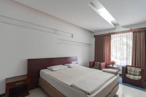 万隆Istana Hotel Bandung Mitra RedDoorz的一间卧室设有一张大床和一个窗户。