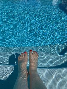 龙尚Insolite avec piscine Au Bonheur Comtois的站在游泳池旁的脚下