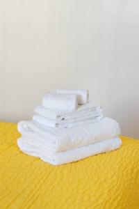 奥克兰Modern Cottage near many conveniences的一张黄色桌子上堆着的白色毛巾