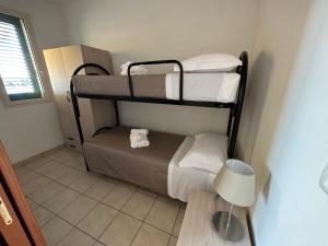 贝瓦尼亚圣彼得Appartamenti Le 2M的小房间设有三张双层床和灯