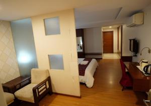 卡努尔Hotel Sasya Pride的配有一张床和一张书桌的酒店客房