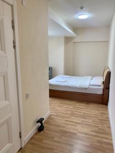 乌兰巴托2 bedrooms apartment的一间卧室配有一张床,另一间卧室铺有地板。