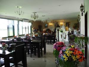 南府Doi Samoe Dao Hostel的一间带桌椅和鲜花的用餐室