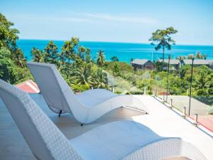 苏梅岛Villa Maviela Sea View 2 Bdr的一张白色椅子,坐在一个俯瞰大海的阳台
