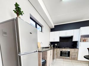 内尔斯普雷特Luxury Lowveld Apartment的厨房配有白色橱柜和冰箱。