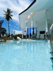 清迈Moose Hotel Chiangmai的大楼前的蓝色海水大型游泳池