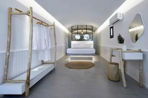 佩里沃罗Oscar Beachfront Suites - Adults Only的更衣室配有床和镜子