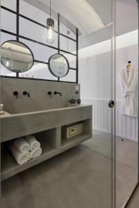 佩里沃罗Oscar Beachfront Suites - Adults Only的一间带水槽和镜子的浴室