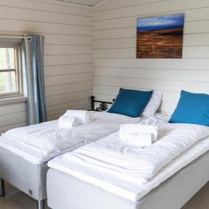 阿尔塔Gargia Lodge的一张大白色的床,房间配有蓝色枕头