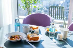 东京Tokyu Stay Kamata - Tokyo Haneda的一张蓝色桌子,上面放有食物和瓶装水