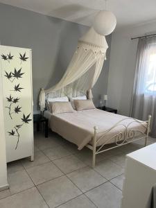 兹雷帕农亚历山德罗斯公寓的一间卧室配有一张带天蓬的白色床