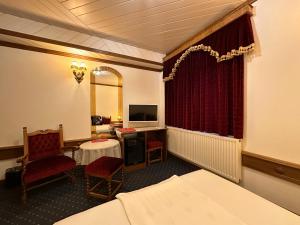 维斯普雷姆Éllő Residence的酒店客房配有一张床、一张书桌和一台电视。