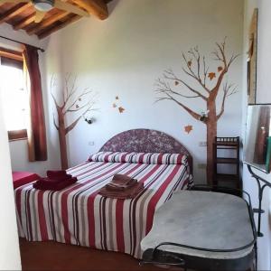 斯坎萨诺Agriturismo Salaiolo 176的卧室配有一张墙上树木环绕的床