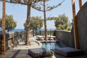 佩里沃罗Oscar Beachfront Suites - Adults Only的木制走道上带两个脚凳的游泳池