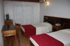 布拉干萨克拉西斯酒店的一间设有两张床和一张桌子的房间