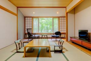 日光Kyukamura Nikko-Yumoto的客房设有桌椅和窗户。