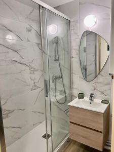 卡布尔Plage Cabourg 7 Vue Mer的带淋浴、盥洗盆和镜子的浴室