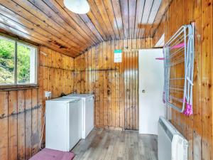 Inverey米尔代洛克小屋的洗衣房设有木墙和冰箱