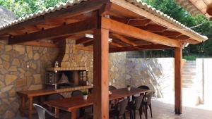 KorakádesVilla Korakades的木制凉棚下的木桌和椅子