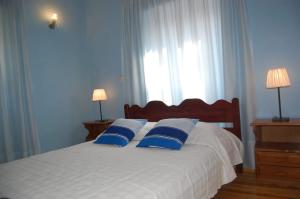 KorakádesVilla Korakades的一间卧室配有白色床和蓝色枕头