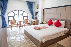 Long ThànhKhang Thịnh Hotel Long Thành的一间卧室配有一张带红色枕头的大床