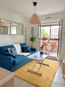 卡布尔Plage Cabourg 7 Vue Mer的客厅配有蓝色的沙发和桌子