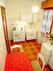 利尼亚诺萨比亚多罗Lignano Riviera的一个带桌子和红色桌子的西德西德西德西德西德小厨房
