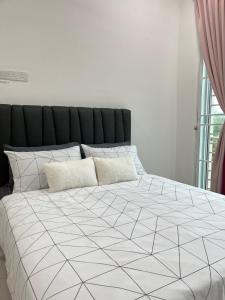 瓜拉丁加奴Anjung Rindu Homestay (Kuala Terengganu, UMT, UniSZA)的一间卧室配有一张带黑白色棉被的床