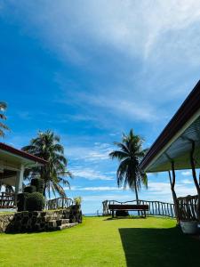 曼巴豪Tongatok Cliff Resort的一个带野餐桌和棕榈树的公园