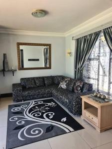 德班Umhlanga Guesthouse flat的带沙发和地毯的客厅
