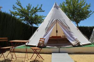 塞特尼尔Casas Rurales el Nogalejo Setenil的白色帐篷,配有两把椅子和一张桌子