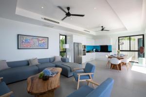 苏梅岛Villa La Moon Chaweng Noi 4BR的客厅配有蓝色的沙发和桌子
