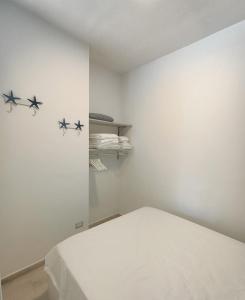 马达莱纳Appartamento Tizzy的白色的客房设有一张墙上的星空床。