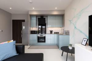 吉林汉姆Luxury Apartments in Gillingham的一间配有沙发和桌子的厨房