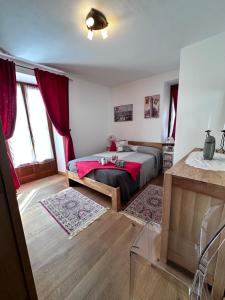 普雷圣迪迪埃Bilocale Centro Pré-Saint-Didier的一间卧室配有一张带红色毯子的床
