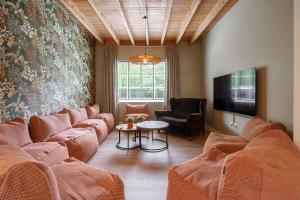 ZarrenHulstehof的客厅配有橙色沙发和电视