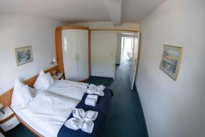 黑尔戈兰岛鸿恩霍尔特酒店的一间卧室,配有一张带弓的床铺