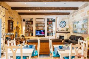 ŻebbuġRest, restore, explore. An exclusive stay in Malta的客厅配有桌椅和壁炉