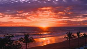 塞米亚克Potato Head Suites & Studios的棕榈树海滩上的日落和海洋
