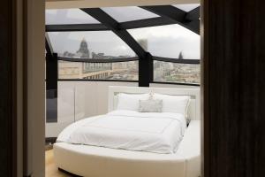 布鲁塞尔Triplex penthouse in the city center的配有大窗户的客房内的白色床