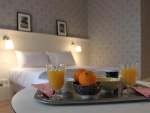 里摩日La Maison Blanche - AppartHôtels climatisés de charme Chic & Cosy - Centre-ville的一间酒店客房内的托盘,上面摆放着水果和饮料