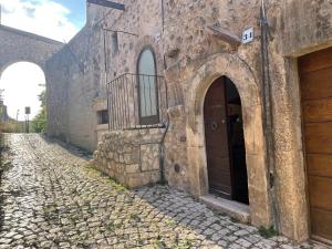 圣斯特凡诺·迪塞斯Terra della Baronia的一条古老的石头建筑,有两扇门,一条鹅卵石街道
