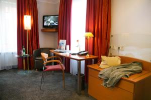 汉堡Hotel AM ELBUFER的酒店的客房配备了书桌、床和电视。