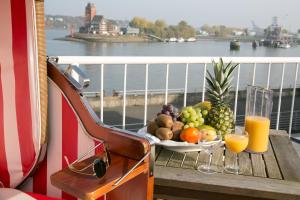 汉堡Hotel AM ELBUFER的一张桌子,上面放着一碗水果和橙汁