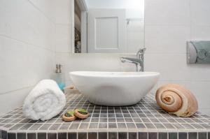 米科利维亚Victoria Studios & Apartments的浴室设有白色水槽和镜子