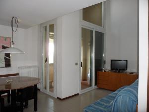 蓬塔阿拉Appartamento 109 - Multiproprietà I Boboli BC的带沙发、桌子和电视的客厅