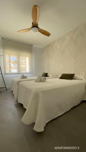 阿尔巴塞特Urbanlux Belmonte Suite的白色客房的两张床,配有吊扇