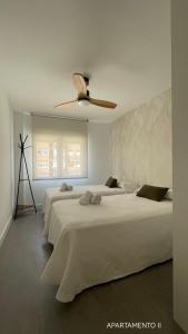 阿尔巴塞特Urbanlux Belmonte Suite的一间卧室配有两张床和吊扇
