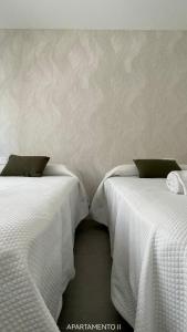 阿尔巴塞特Urbanlux Belmonte Suite的两张睡床彼此相邻,位于一个房间里